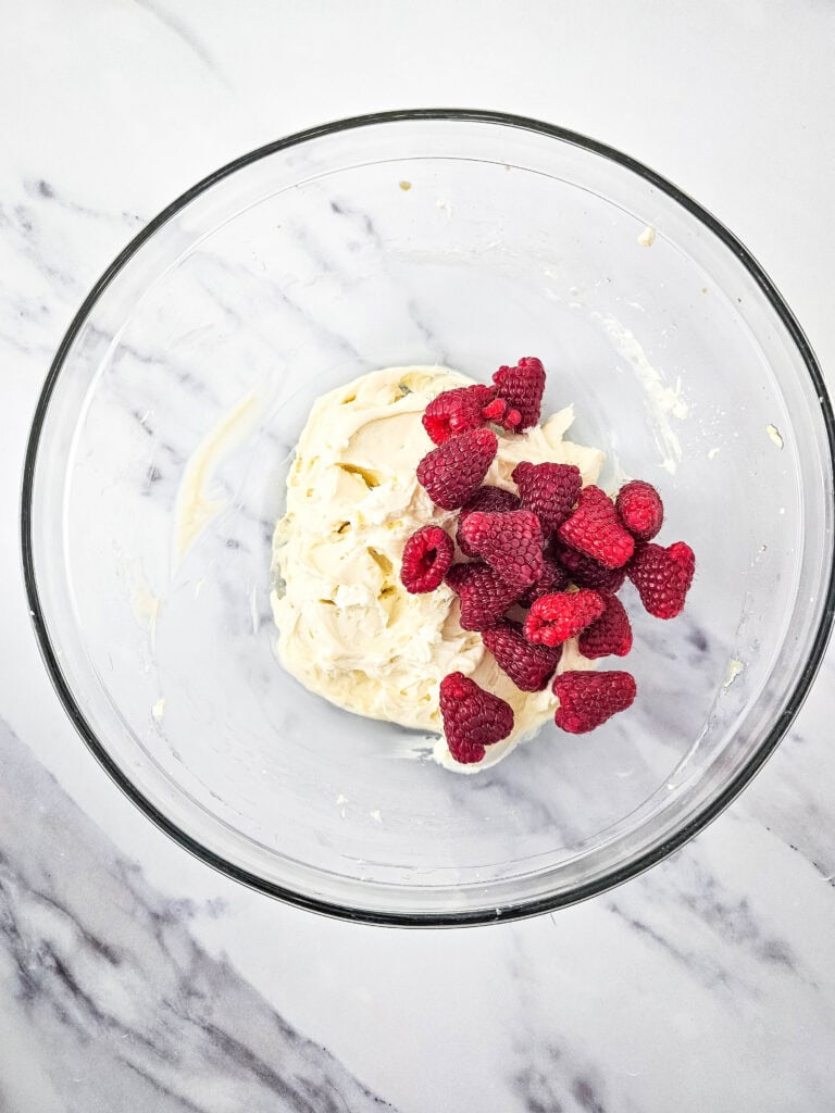 adding raspberries for no bake raspberry cheesecake parfait