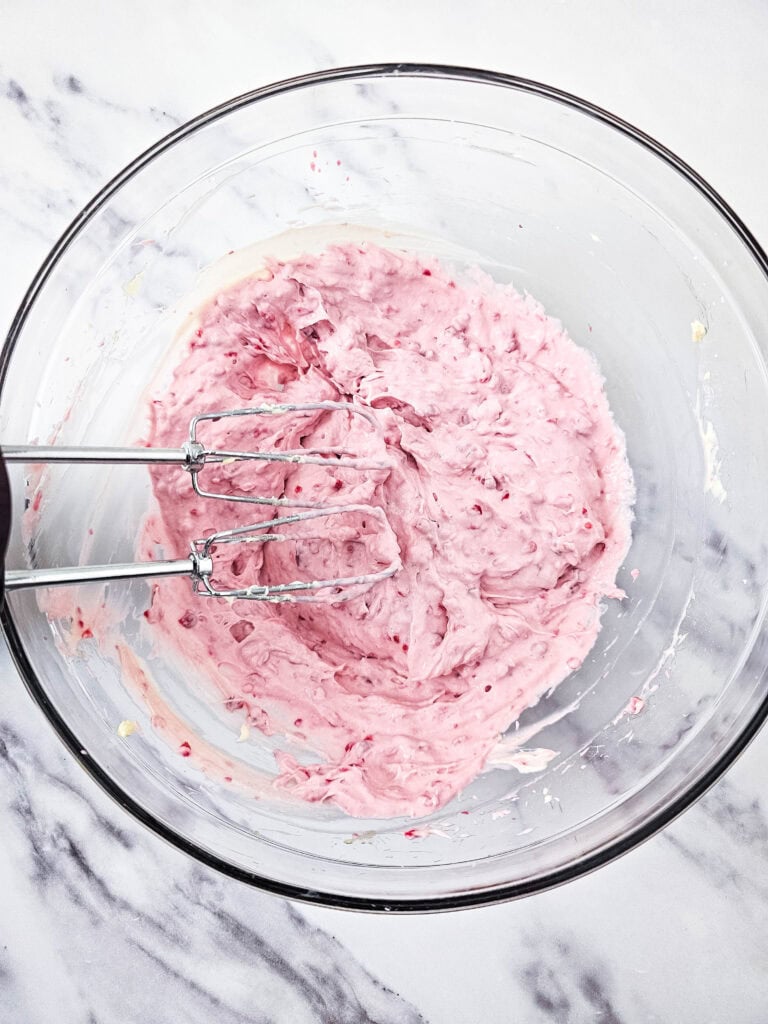 mixing cream cheese and raspberries for no bake raspberry cheesecake parfait