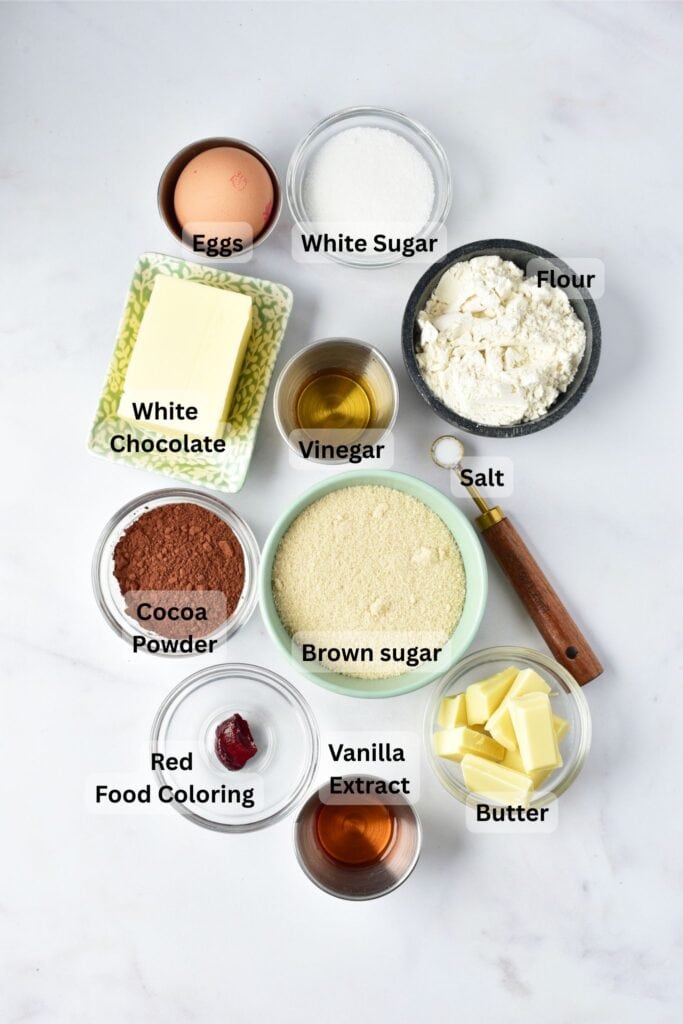 Red velvet brownie ingredients arranged on a white surface in small bowls.